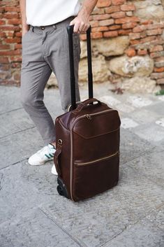 Upgrade your travel experience with our Handmade Italian Leather Rolling Suitcase, a perfect blend of luxury and functionality. Crafted from the finest Tuscan vacchetta leather, this rolling suitcase showcases the rich heritage and artisanal skill of Montepulciano. Designed for both men and women, this carry-on bag combines elegance with practicality, making it an ideal choice for both business trips and vacations. Features: ◉ Premium Material: Made from 100% genuine Tuscan vacchetta leather, ce Luxury Leather Backpack For Travel In Cognac, Luxury Cognac Leather Backpack For Travel, Luxury Cognac Leather Travel Backpack, Luxury Travel Shoulder Bag Rectangular Case, Luxury Travel Shoulder Bag With Rectangular Case, Luxury Rectangular Travel Shoulder Bag, Brown Large Capacity Luggage For Business Trips, Large Capacity Brown Luggage For Business Trips, Leather Travel Briefcase With Large Capacity