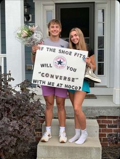 two girls holding a sign that says if the shoe fits will you converse with me at hog?