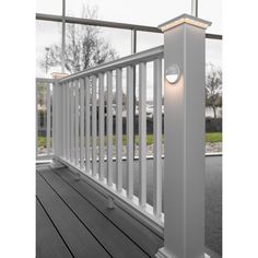 a white porch light sitting on top of a wooden deck