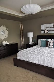 a large bed sitting in a bedroom next to a dresser and lamps on either side of the bed