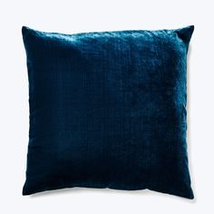 a blue velvet pillow on a white background