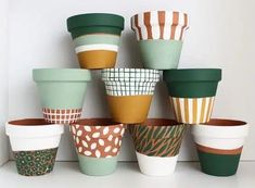 a bunch of cups that are sitting on a shelf together in front of a wall