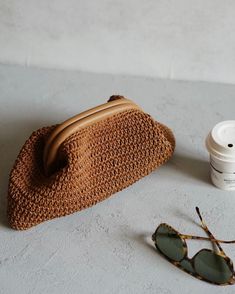 a purse, sunglasses and coffee cup on a table