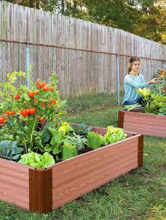 a wooden planter filled with lots of vegetables