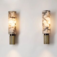 two wall lights with marbled glass shades on them