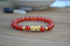 "This is Pure Real 24 Karat Gold Pixiu/Natural Carnelian Gold Pixiu Piyao( less than 1 g ) - Approximately 13mm x 6mm 14 karat Gold Beads Round - Approximately 3mm Carnelian Beads - Approximately 6mm Hallmark/Stamp 999 for 24k Gold (PIXIU) Please select bracelet size. All are handmade with care .Strung on heavy duty stretchy/elastic. Products and photo may differ. Bracelet Comes with Storage Bag & Box How to Determine Bracelet Size: Step 1: Measure your wrist just below the wrist bone, where Red Carnelian Bracelets With 8mm Beads, Amber Carnelian Beaded Bracelets - Gift, Amber Carnelian Beaded Bracelet Gift, Red Carnelian Beaded Bracelets For Gift, Red Carnelian Bracelets As Gift, Red Carnelian Bracelets As A Gift, Red Carnelian Bracelets For Gifts, Gold Carnelian Beaded Bracelets For Spiritual Wear, Red Agate Bracelets For Meditation