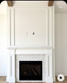 an empty living room with a fireplace and white walls