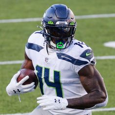 a football player running with the ball in his hand and wearing a helmet on it's head