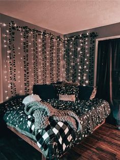 a bed sitting next to a window covered in lights