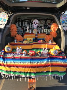 the trunk of a car is decorated with sugar skulls and mexican themed decorations, such as tacos