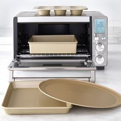 a toaster oven sitting on top of a counter next to pans and trays