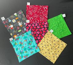 four different colored cloths on a black surface