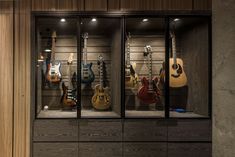 the guitars are lined up in the glass display case on the wall behind the counter