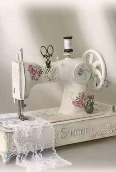 a white sewing machine sitting on top of a table next to a pair of scissors