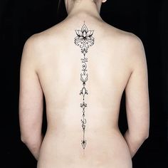 the back of a woman's body with tattoos on her upper and lower back