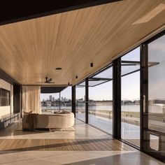 an empty room with large windows overlooking the water