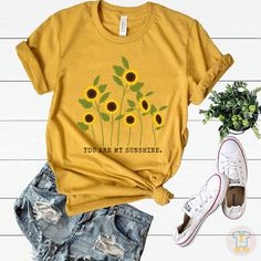 You are my sunshine T shirt, Sunflower T-shirt,Sunflower lover, Graphic Tee, Sunflower Tee,Inspirational Tee, Womens Floral Tee,Botanical Shirt,Garden shirt. This t-shirt is everything you've dreamed of and more. It feels soft and lightweight, with the right amount of stretch. It's comfortable and flattering for both men and women. * 100% combed and ring-spun cotton (Heather colors contain polyester) * Ash color is 99% combed and ring-spun cotton, 1% polyester * Heather colors are 52% combed and Garden Shirt, Coffee Sweatshirt, Botanical Shirt, Inspirational Tees, Gardening Shirts, Floral Tee, Holiday Sweatshirt, T Shirt Photo, Flower Shirt