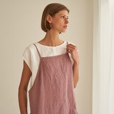 "Haven - everyday pinafore dress with endless styling possibilities. FEATURES: * comfy pockets * loose cut * dress length is 90 cm / 35.4\" (size S) * 100 % natural, certified linen fabric * dyed and washed in small batches * natural cotton yarns * biodegradable button frontline * handmade at a small studio in Europe COLORS: Dyed and washed in small batches, so the color will be unique and superb quality to each piece. Please check the color options on the side menu. SIZE GUIDE / BODY MEASUREMEN Essential Clothing Pieces, Linen Pinafore Dress, Pale Dogwood, Japanese Style Apron, Linen Apron Dress, Linen Pinafore, Linen Wrap Dress, Linen Sundress, Cut Dress