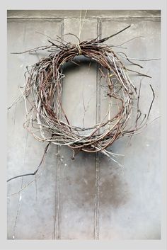 a close up of a wreath on a door with vines hanging from the front and side