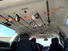 there are many fishing rods hanging from the ceiling in this vehicle's cargo area