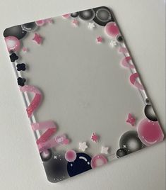 a square shaped mirror with pink and black decorations