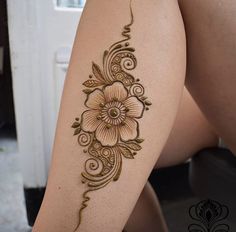 a woman's legs with hendix tattoos on her leg and one flower in the middle