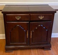 a wooden cabinet sitting on top of a hard wood floor