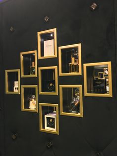 a black wall with gold framed pictures on it