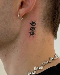 a man's neck with an evil eye tattoo on the back of his neck