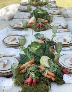 a long table is set with vegetables and place settings for an outdoor dinner or brunch