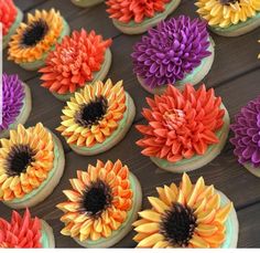 cupcakes decorated with colorful flowers on a table