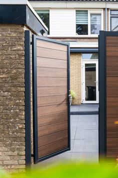 an open wooden door in front of a brick building