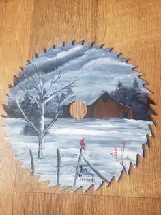 a circular saw blade with a house and tree on it