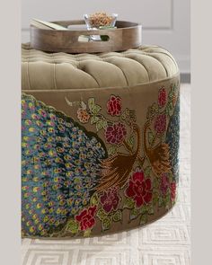 the ottoman is decorated with colorful flowers and birds on it's back end, along with a tray