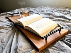 an open book sitting on top of a wooden tray