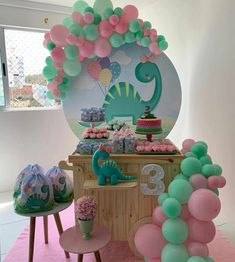 a dinosaur themed birthday party with balloons and cake