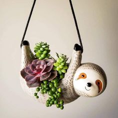 a slotty planter with succulents and plants hanging from it's sides