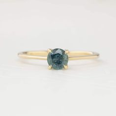 Approximately 0.55ct. 5mm Montana sapphire, eye clean Band width: 1.1mm to 1.4mm tapered band High profile four prongs flower setting Made of 100% recycled solid 14k gold and ethically sourced gemstones Colors may vary slightly as they are genuine gemstones Photos of the ring on the model are using a different ring, please refer to the main photo and video Packaged in a white craft paper ring box Custom Order This ring is offered in other sizes, metal, and the center stone can be upgraded/downgr Timeless 14k Gold Sapphire Ring With Tension Setting, Yellow Gold Sapphire Ring With Tension Setting, Minimalist Yellow Gold Sapphire Ring With Prong Setting, Yellow Gold Sapphire Solitaire Ring, Green Montana, Flower Setting, Ivory Ring, Montana Sapphire Ring, Sapphire Solitaire Ring