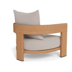 a chair that is made out of wood and has pillows on the armrests