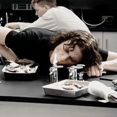 a woman is laying on the table with food