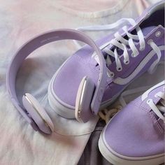 pair of purple sneakers with white laces on them sitting on top of a bed