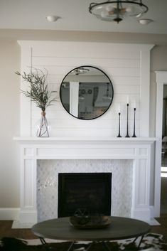 a living room with a fire place and a mirror on the wall above it's mantle