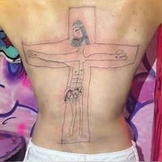 a woman with a tattoo on her back that has a drawing of jesus on it