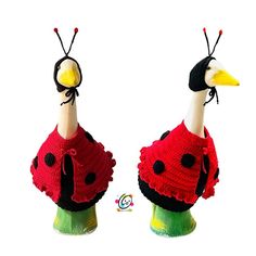 two stuffed birds wearing sweaters and hats on top of each other's heads