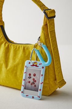 a yellow purse with a blue keychain hanging from it