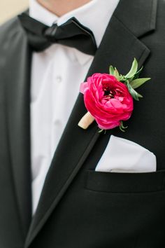 a man wearing a tuxedo with a pink flower on it's lapel