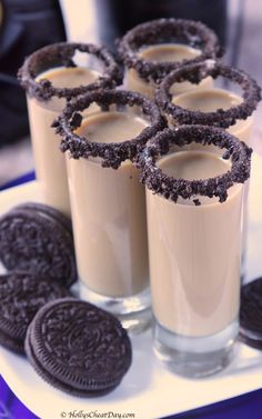 four glasses filled with cookies on top of a white plate