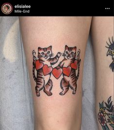 two cats with hearts on their legs, one is holding the other's leg