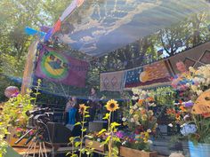 an outdoor stage with flowers and banners in the background