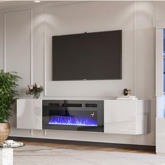 an entertainment center with a large television mounted on the wall and a fireplace in front of it